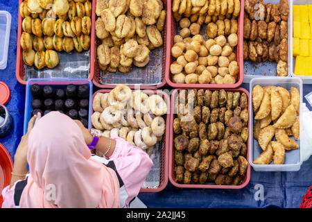 Top view of unidentified vendor and customer at the food stall in Kota Kinabalu city food market. Stock Photo