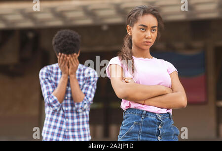 Teenagers having relationship difficulties. Girl sulking to her upset boyfriend Stock Photo