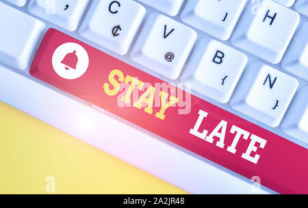 Text sign showing Stay Late. Business photo showcasing A routine in which a demonstrating goes to somewhere out of time White pc keyboard with empty n Stock Photo