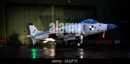 British aerospace Sea Harrier FA/2 built as FRS1 of 899 NAS stands outside a hangar at night lit up Stock Photo