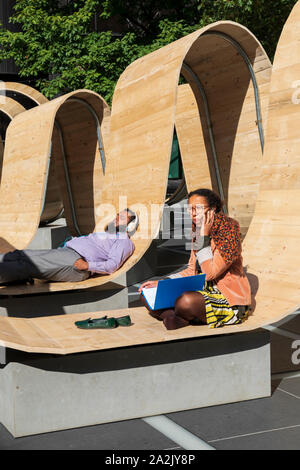 Visitors relax on the Please Be Seated installation by Paul Cocksedge at The London Design Festival 2019 in Finsbury Avenue Square, Broadgate, London. Stock Photo