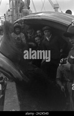 Die Männer des Fabrikschiffs 'Jan Wellem' der deutschen Walfangflotte posieren im Maul des Kadavers eines Wals, 1930er Jahre. The crew of a factory vessel of the German whaling fleet is posing in the mouth of the cadaver of a hunted down whale, 1930s. Stock Photo