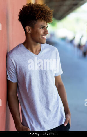 Portrait of thinking african american young adult man outdoors in summer Stock Photo