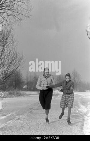 Mutter und Tochter beim Eislaufen auf einem zugefrorenen See im Spreewald, Deutschland 1930er Jahre. Mother and daughter skating on a frozen lake at Spreewald area, Germany 1930s. Stock Photo