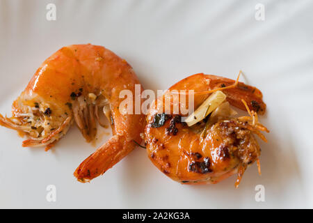 Fried big tiger red cooked prawns or shrimps on white plate closeup. View from above. Stock Photo