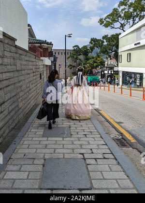 SEPT. 19, 2019-SEOUL SOUTH KOREA : Yougn woman dressed with a traditional korean hanbok dress walking with a woman wearing a modern clothes. Strolling Stock Photo