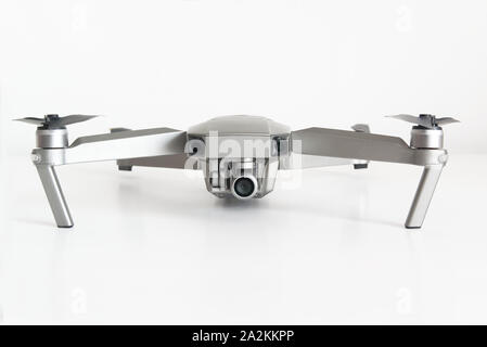 Isolated quadcopter drone on a white surface showing its camera against a white background. Empty copy space for Editor's text. Stock Photo