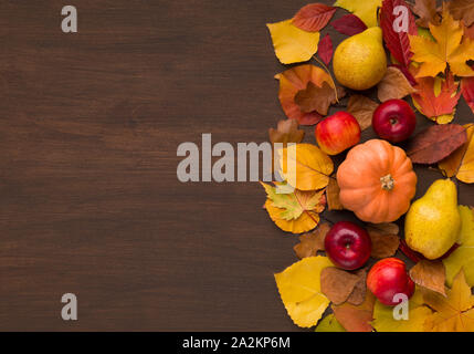 Autumn harvest of red apples and pumpkin on fallen leaves Stock Photo