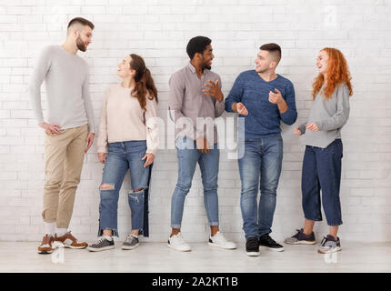 Young stylish friends talking, having break at college Stock Photo