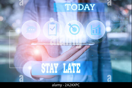 Text sign showing Stay Late. Business photo showcasing A routine in which a demonstrating goes to somewhere out of time Female human wear formal work Stock Photo