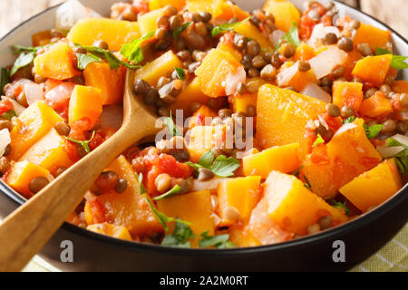 Homemade pumpkin ragout with lentils, onions and carrots in a bowl close-up on the table. horizontal Stock Photo