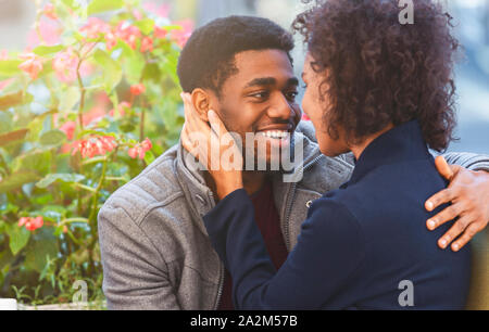 Afro couple in love telling each other sweet words, hugging Stock Photo
