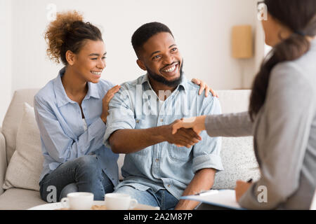 Young African American Couple Handshaking With Marriage Counselor After Therapy Stock Photo