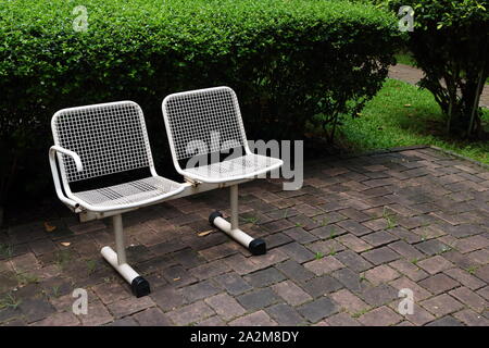 Closeup two empty white chairs made of stainless steel with grid pattern, silence concept Stock Photo