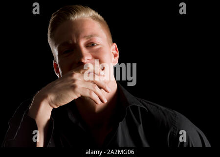 Low key portrait of joyful man looking straight. Stock Photo