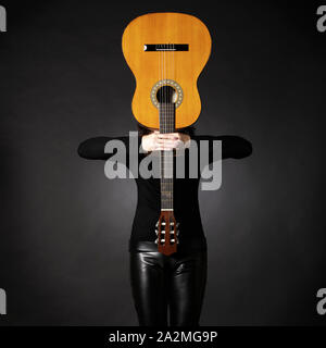 Woman with guitar in front of head. Stock Photo