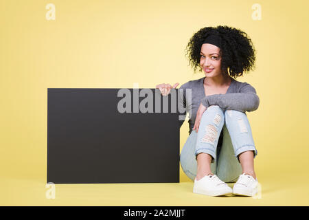 Happy girl holding a blank sign with copyspace. Stock Photo