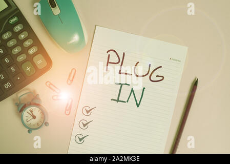 Writing note showing Plug In. Business concept for putting device into electricity to turn it on Power it Connecting Calculator clips alarm clock mous Stock Photo