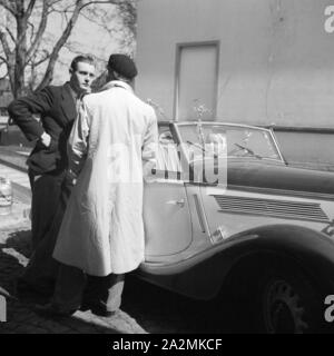 Zwei Männer und eine Frau an einem Ford Eifel, Deutschland 1930er Jahre. Two men and a woman with a Ford model Eifel, Germany 1930s. Stock Photo