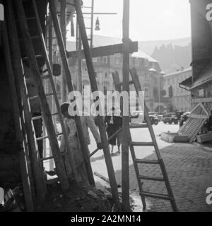 Lehrling auf einer Baustelle in einer Innenstadt in Deurschland, 1930er Jahre. Apprentice boy on a construction area in a city centre of Germany, 1930s. Stock Photo