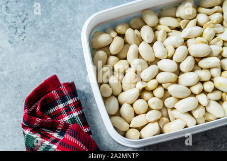 Organic Unsalted White Peeled Raw Peanuts in Plastic Box Container / Package. Organic Food. Stock Photo