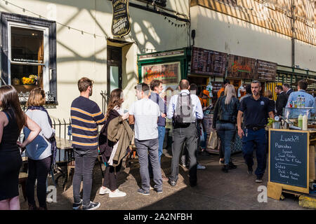 People queueing for takeaway at food stall, St Nicholas Market, Bristol, UK Stock Photo