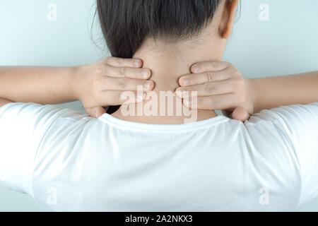 Closeup woman neck and shoulder feeling exhausted and suffering from neck and shoulder pain and injury on white background. Health care and medical co Stock Photo