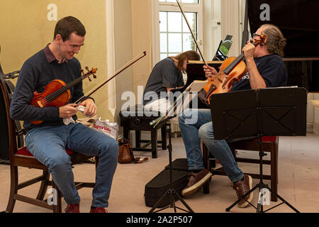 Musicians enjoying a joke while they rehearse Stock Photo