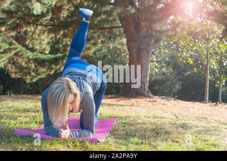 Premium Photo  Girl in a light tracksuit doing yoga in the park in the  afternoon in the summer