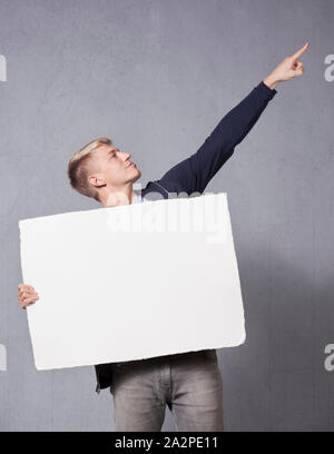 Cheerful man holding white blank signboard. Stock Photo