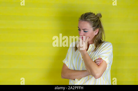 Beautiful young woman with hand on chin thinking about question, pensive expression. doubt concept Stock Photo