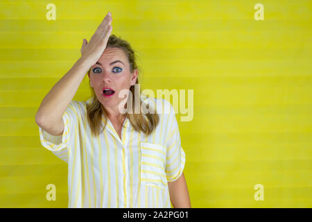 woman over isolated background surprised with hand on head for mistake. Forgot, bad memory concept. - Image Stock Photo