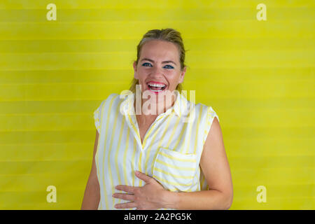 Beautiful woman with painted lips on isolated background Smiling and laughing out loud because funny joke. Happy expression - Image Stock Photo