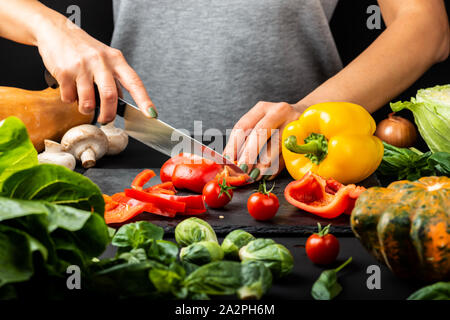 Woman's hands prepare vegetarian food, cut different vegetables. Healthy eating diet concept. Stock Photo