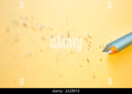 Sharpened wooden pencil on yellow background , beautiful pencil shavings all around Stock Photo