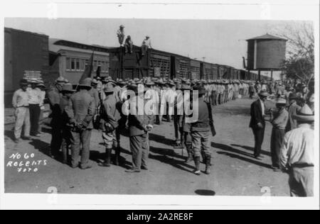 Railroad trains transporting Insurrectos during the Mexican Revolution: Side view with many soldiers standing alongside Stock Photo