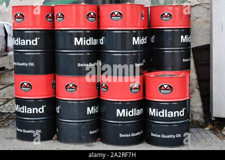 barrels of 'Midland Swiss Quality Oil'engine lubricant stacked in the yard of a service garage. Stock Photo
