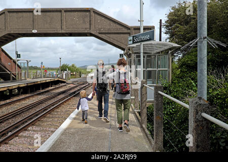 Family with child & rucksacks walking along railway platform at Southease Station after getting off a train from Brighton East Sussex UK KATHY DEWITT Stock Photo