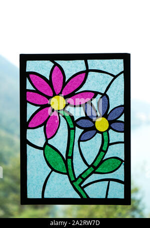 Handmade mosaic with paper.Flower created with transparent paper hanging on the window for decorative purposes Stock Photo