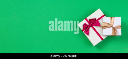 Two gift present boxes with ribbon on green background, top view Stock Photo