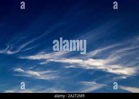 Wispy cirrus clouds against a deep blue sky Stock Photo
