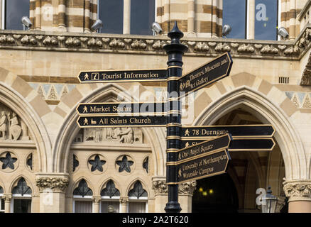 Signpost giving directions to various visitor attractions, with the Guildhall in the background, Northampton,UK Stock Photo