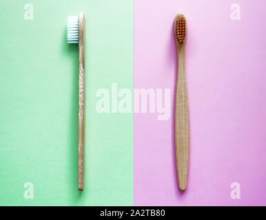 Bamboo toothbrushes on two colored background in trendy green and pink colors. Eco-friendly products. Eco, zero waste and health concepts. Flat lay Stock Photo