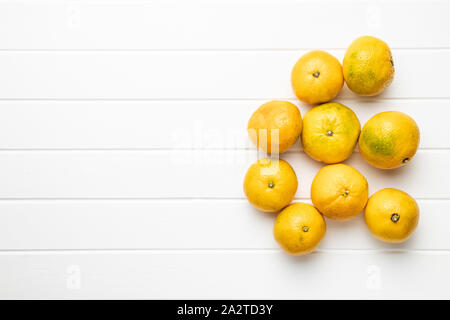 Fresh yellow tangerines on white table. Top view. Stock Photo