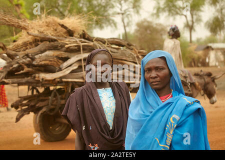 South Sudan Maban Woman with two children in front of her primitive ...