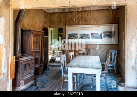 Inside the Tom Miller house at Bodie; view of dining room with stove and table, kitchen visible through doorway. Stock Photo