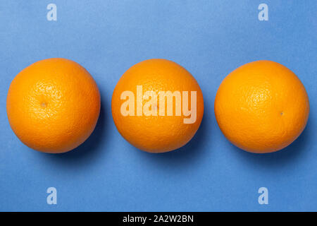 Oranges on the blue background. Flat lay. Stock Photo