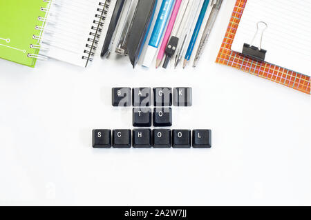 Keyboard keys. Back to school sentence from computer keys with school supplies on isolated white background. Stock Photo