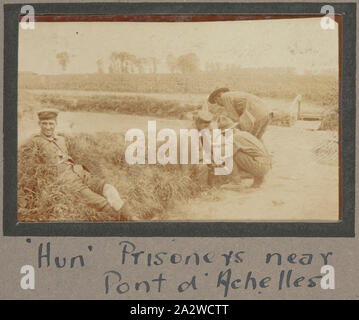 Photograph - 'Hun Prisoners near Pont d'Achelles', France, Sergeant John Lord, World War I, 1916-1917, Black and white photographic print which shows two German prisoners being treated by two New Zealand soldiers. Over the course of World War I Britain had captured 72,000 prisoners of war, most of these just before Armistice in 1918. In comparison, Germany had captured 2.5 million prisoners, with the majority of these being released upon the conclusion of the war. Central Powers