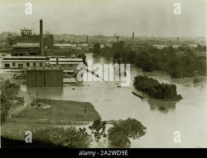 Photograph, Yarra River in Flood, Abbotsford, Victoria, 1934, Black and white silver gelatin sepia toned photograph of the Kodak Australasia factory in Abbotsford, Victoria, 1934. This photograph is an aerial view of the Yarra River in flood in about 1934. At left, the Kodak Powerhouse with its chimney can be seen amidst a group of Kodak factory buildings. The Powerhouse provided all of the power and refrigeration for the factory. The fence line where